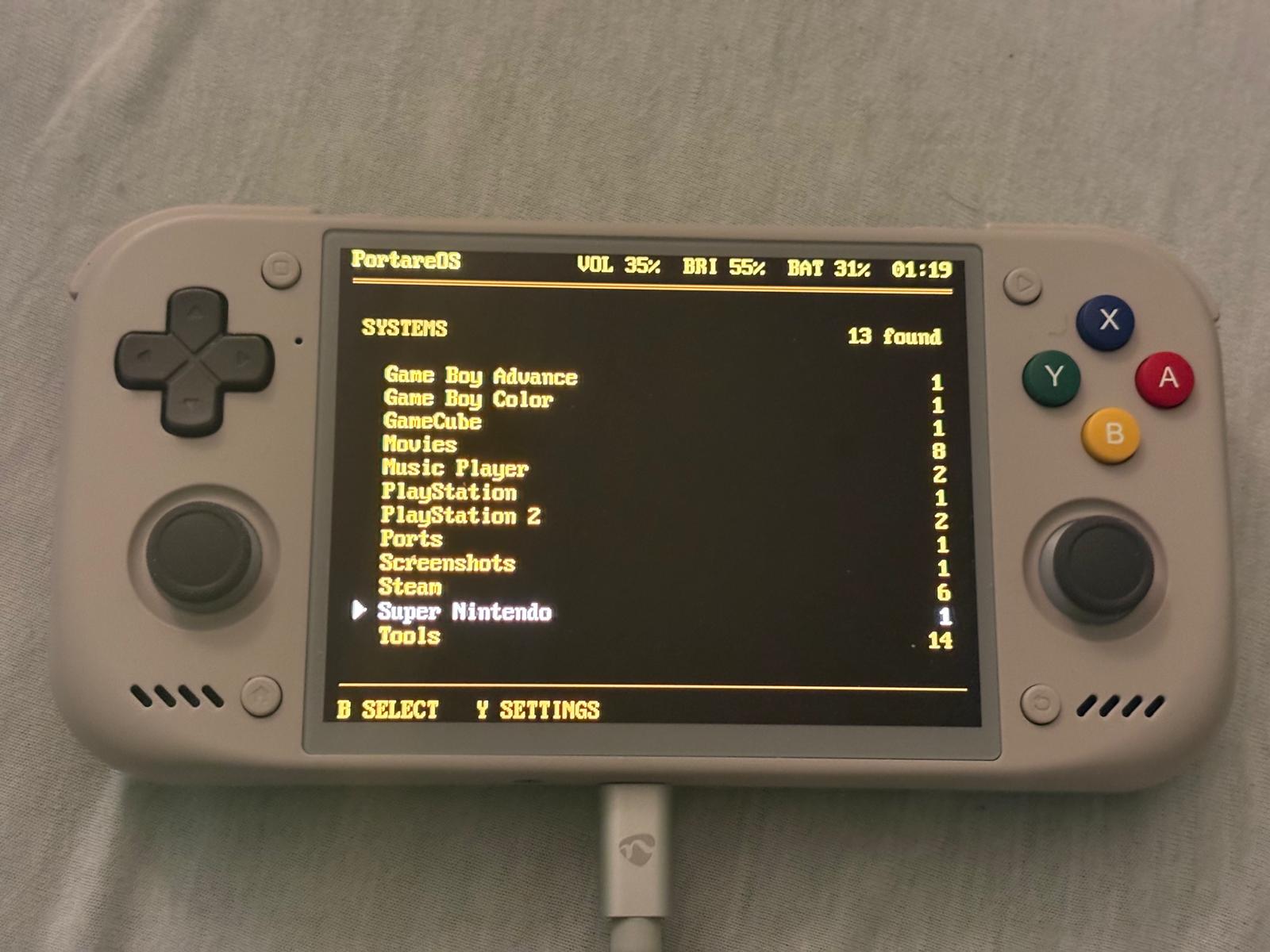 The launcher: a list of systems with game counts, and the volume, brightness, battery and time in the header